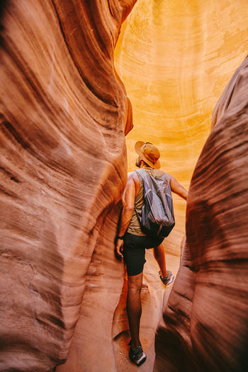 Young man exploring narrow slot canyons in escalante, during summer