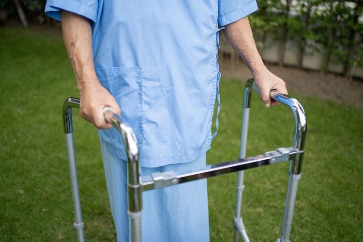 Midsection of man with mobility walker outdoors