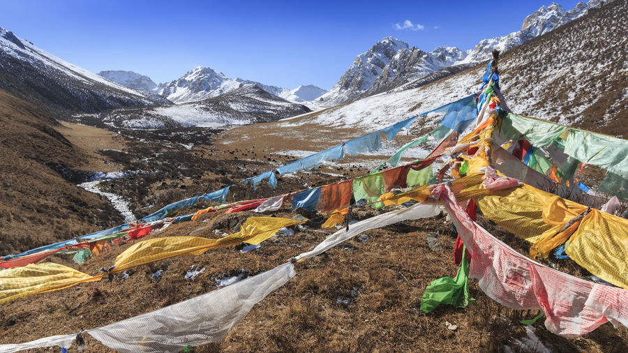 Clothes drying on snow covered landscape against sky