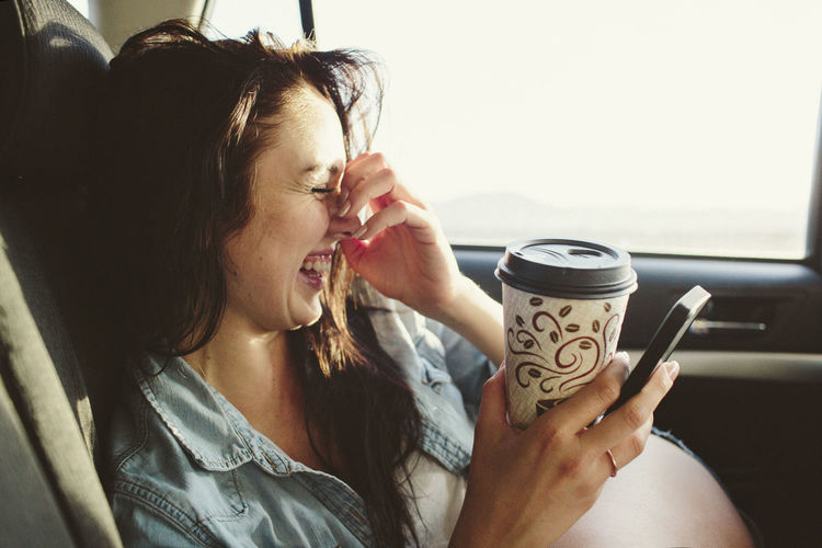 Midsection of young woman drinking coffee