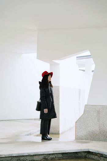 Side view of mid adult woman wearing warm clothing standing in building