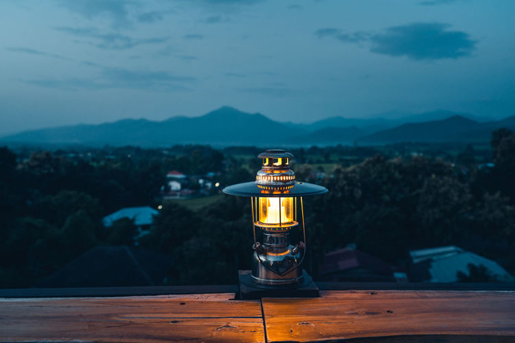 View of lantern on table against mountain