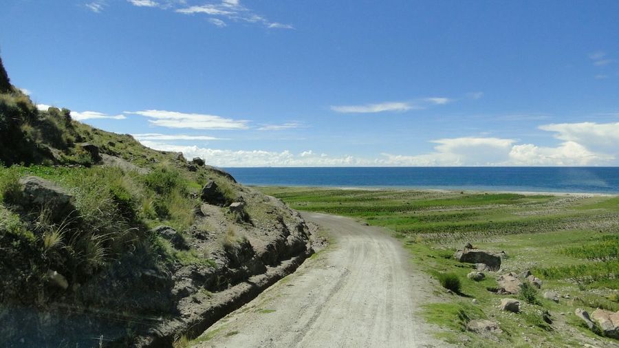 Pathway leading towards lake titicaca against sky