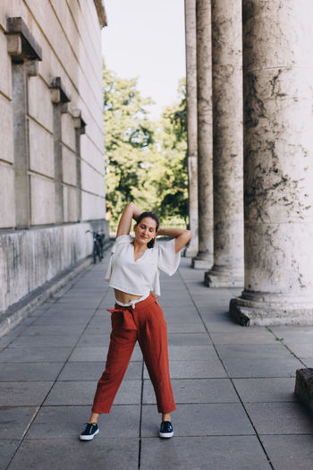 Portrait of woman standing against building