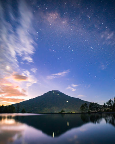 Scenic view of lake against sky at night