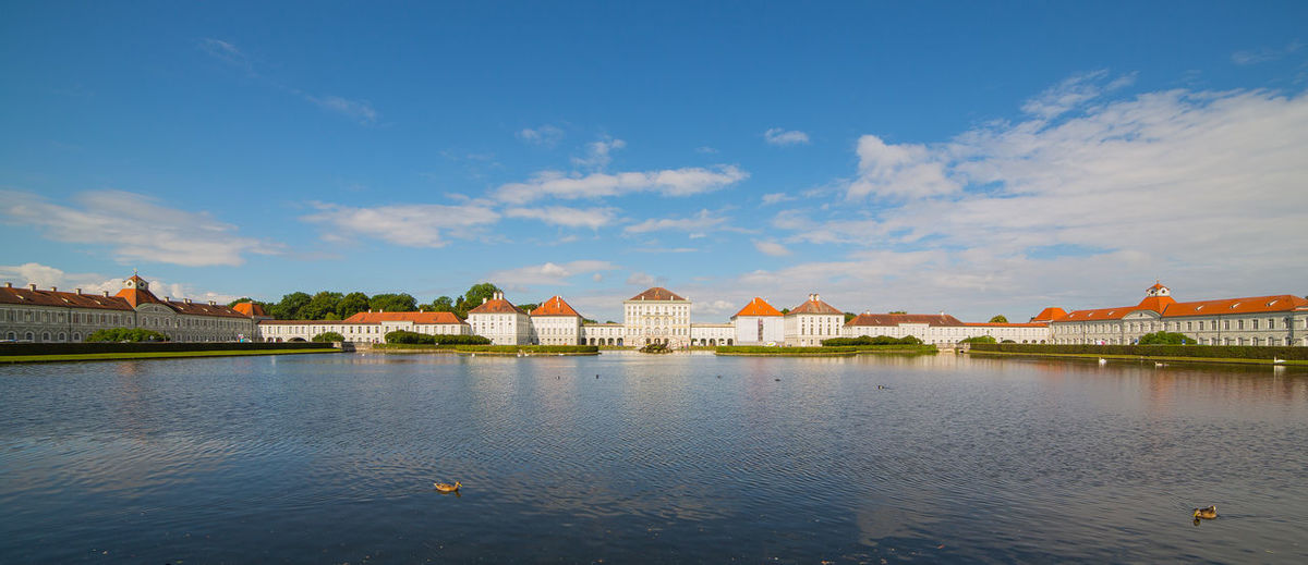 Nymphenburg palace by lake against sky in city