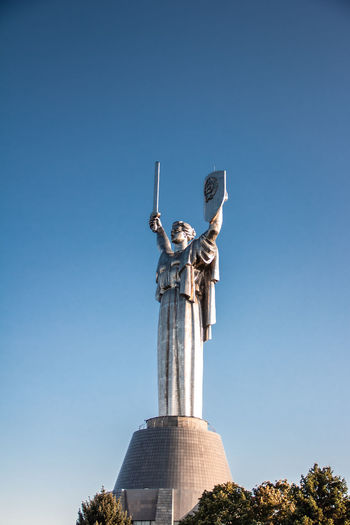 Low angle view of statue against clear blue sky