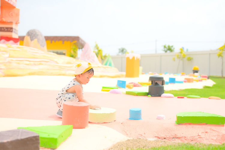 Side view of cute boy sitting on land