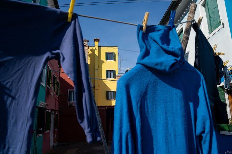Rear view of clothes drying against buildings