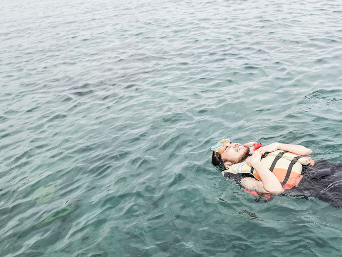High angle view of woman lying in sea
