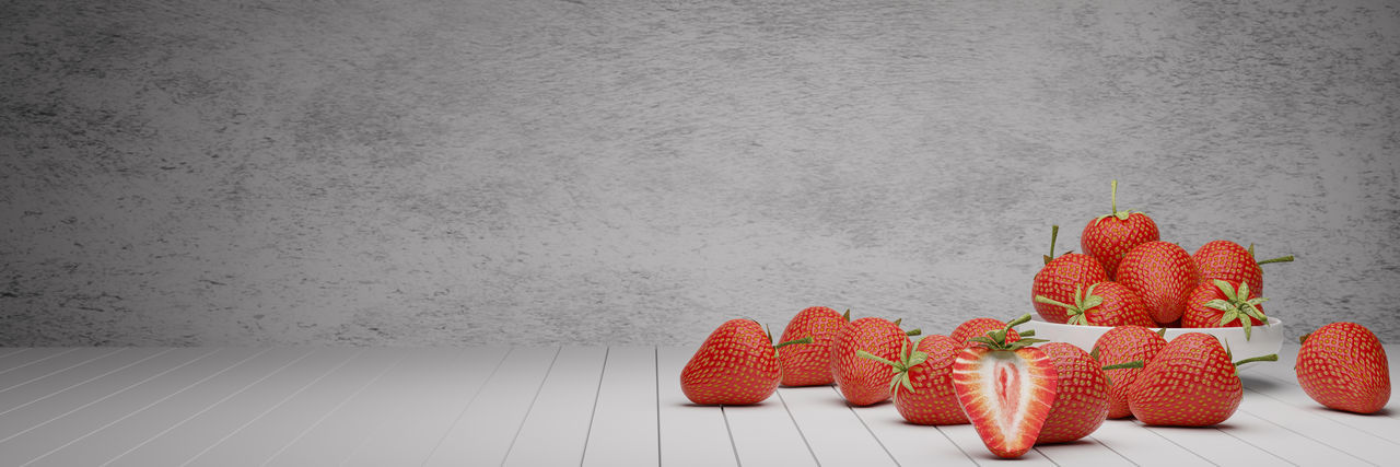 Close-up of strawberries on table against wall at home