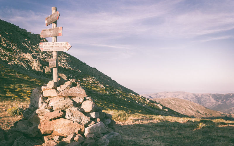 Cross on mountain against sky