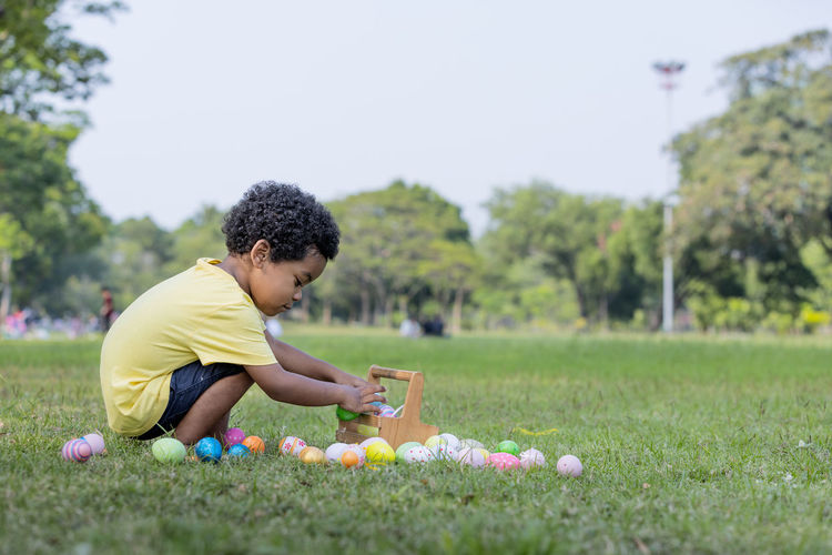 Side view of boy playing with ball at park