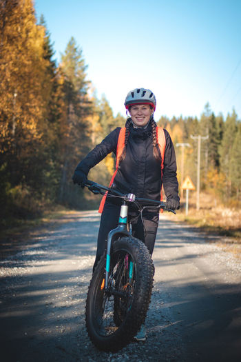 Lady with lovely smile while recreationally sporting. cyclist riding fat bike in finnish  nature. 