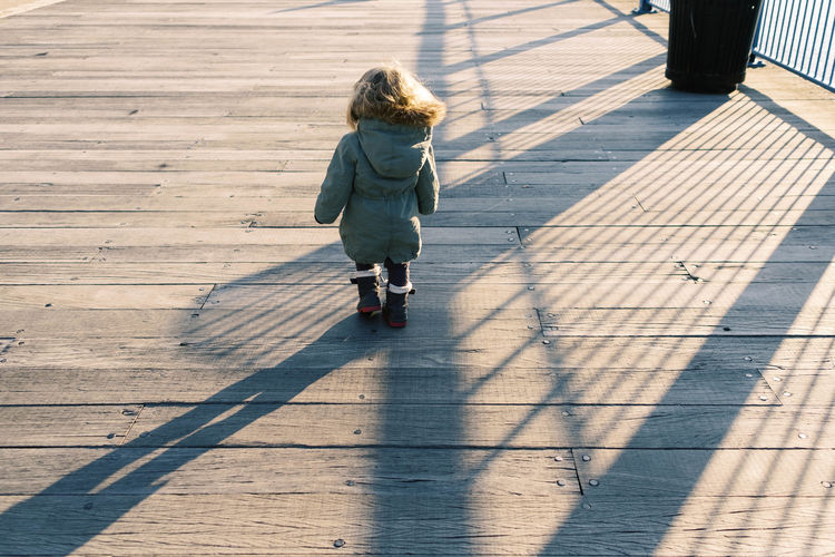 Photo of a toddler girl at the boston harbor during a sunset.