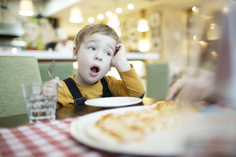 Cute boy sitting at restaurant