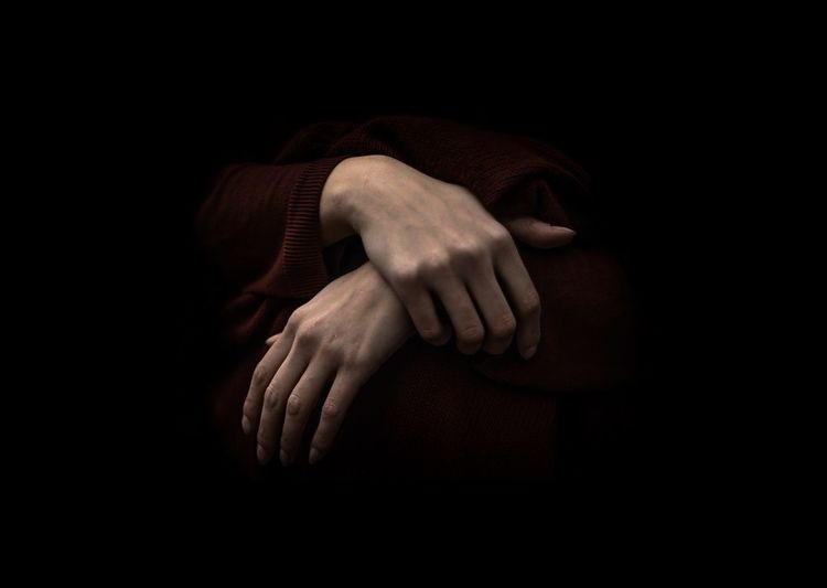 Midsection of woman hand against black background