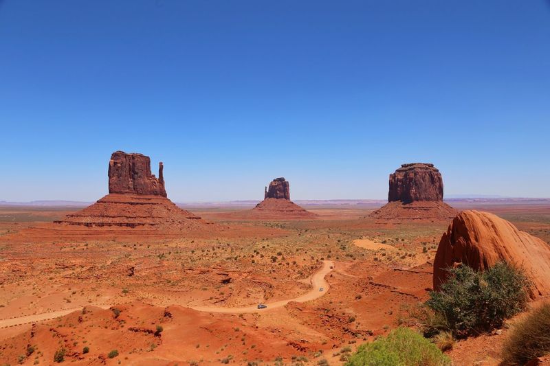 Rock formations in desert at monument valley against clear blue sky