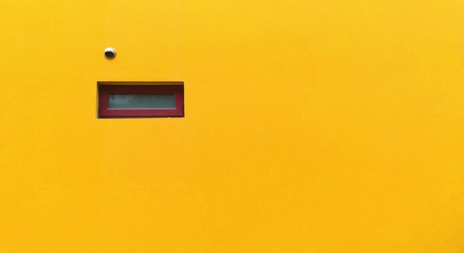 Yellow door with peephole and letter flap