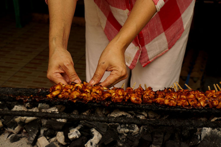 The seller is preparing to make a chicken satay in grilled