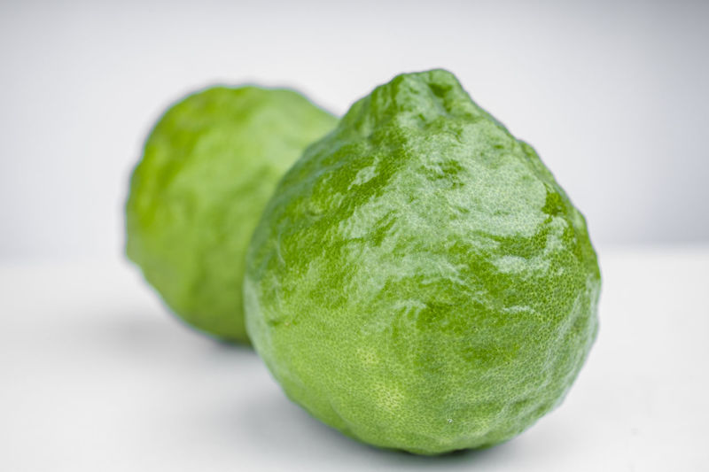 Close-up of green fruit on white background