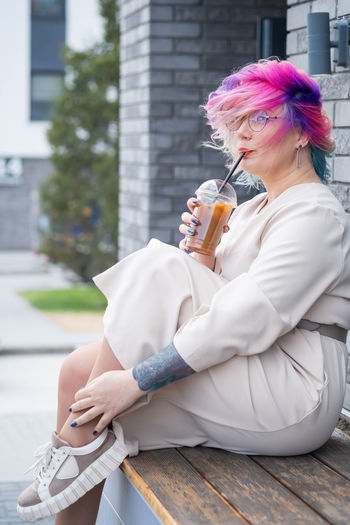 Woman drinking coffee while sitting outdoors