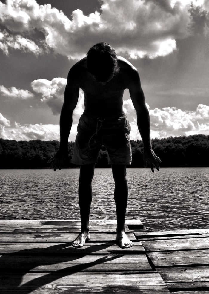 Full length of a man standing on jetty against lake