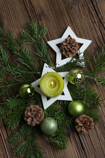 Close-up high angle view of lit candle on wreath