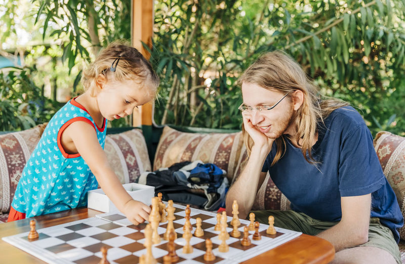 Father and daughter playing chess