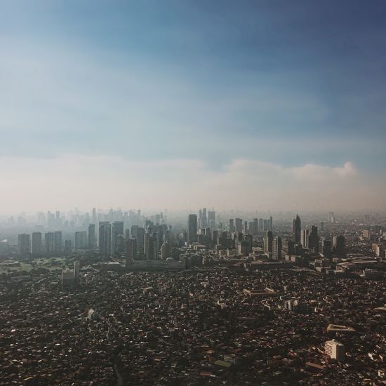 Skyscrapers against cloudy sky