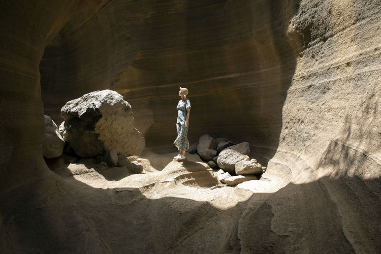 Rear view of woman standing on rock formation