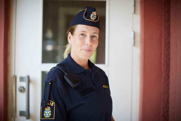 Portrait of policewoman standing outside police station