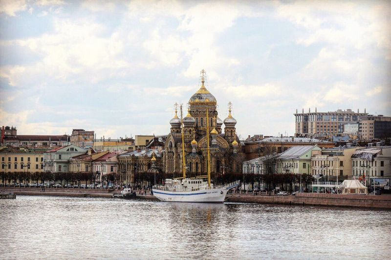 Church of the assumption of the blessed virgin mary by river against sky