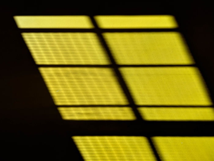Close-up of yellow shadow on window