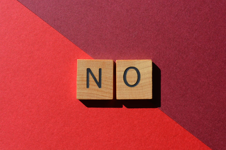 No, word in wooden alphabet letters isolated on red background