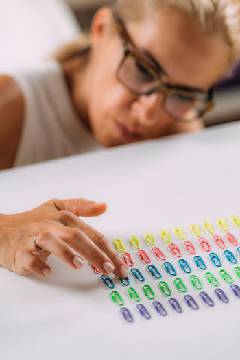 Woman with ocd. obsessive compulsive disorder concept. placing paperclips in a straight line.
