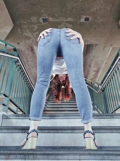 Low angle view of woman touching buttocks while bending on stairs
