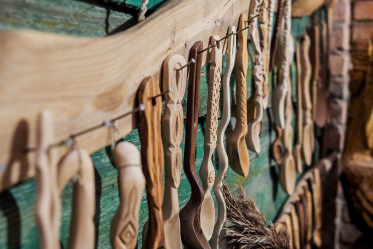 Close-up of wooden spoon hanging at shop for sale