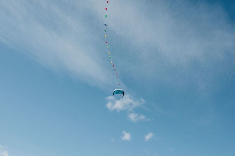 Colourful kite in the sky with fluffy clouds and blu skies