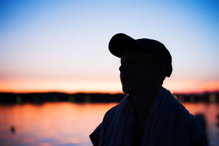 Silhouette man against orange sky