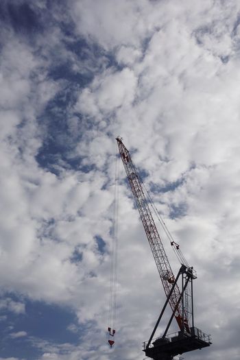 Low angle view of cranes against sky