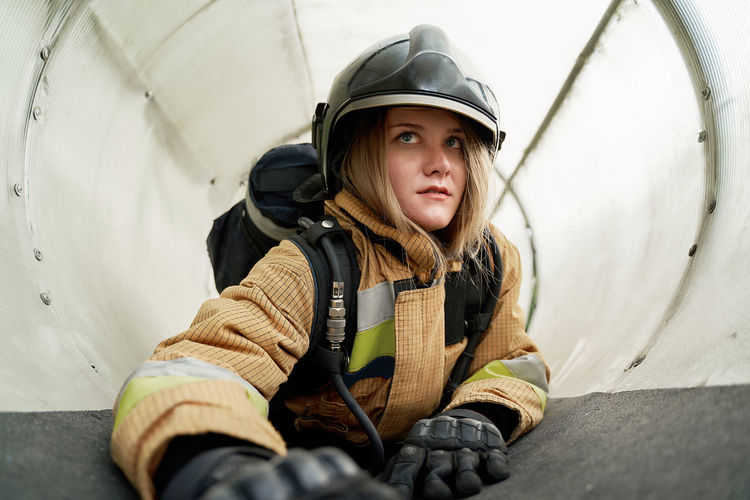 Female firefighter crawling at tube