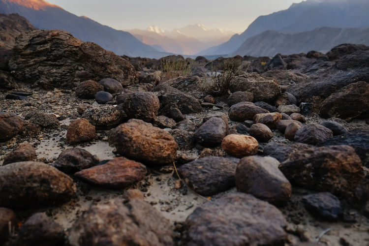 Rocks stones boulders and pebbles against karakoram mountain range. sunset in gilgit, pakistan.