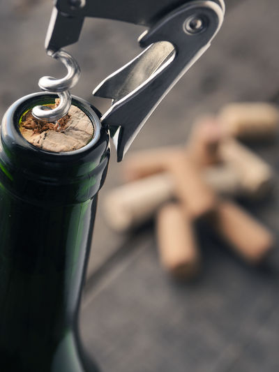 Close-up of bottle opener on wine bottle at table
