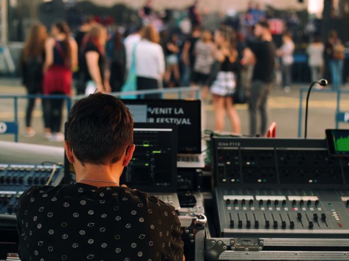 Rear view of dj playing music at concert