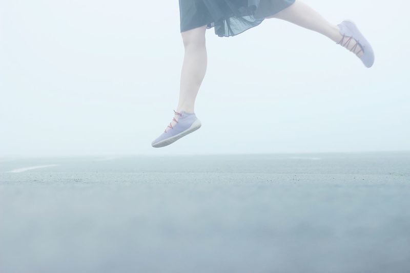 Low section of girl dancing and jumping from ground
