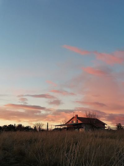 Built structure on field against sky during sunset