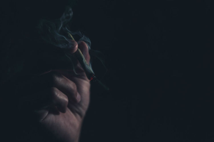 Close-up of hand holding marijuana joint