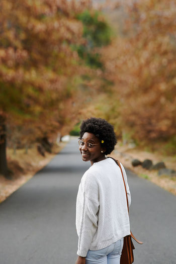 Portrait of smiling woman standing outdoors during autumn