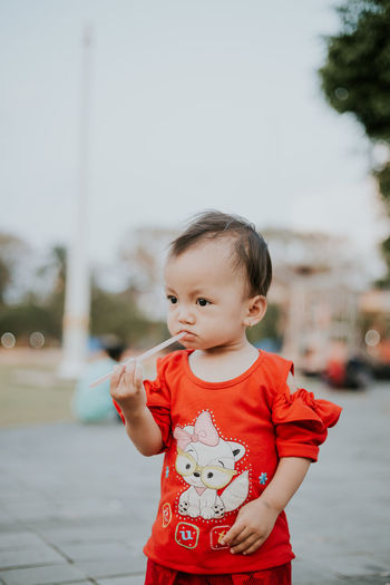 Cute girl with drinking straw at park